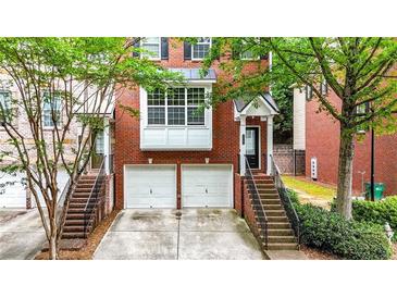 Charming brick townhome featuring a two-car garage and inviting entrance with landscaped surroundings at 5439 Alanis Se Pl # 17, Mableton, GA 30126