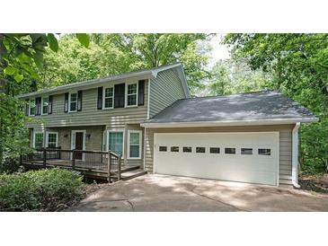 Charming two-story home with a two car garage and a welcoming front porch surrounded by lush greenery at 295 Lakemont Dr, Roswell, GA 30075