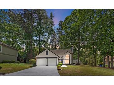 Charming two-story home featuring a two-car garage and landscaped front yard surrounded by mature trees at 5383 Biffle Way, Stone Mountain, GA 30088