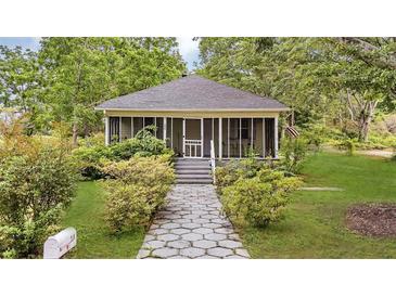 Charming home with a screened-in front porch and a landscaped front yard with a stone pathway at 204 Morris St, Palmetto, GA 30268