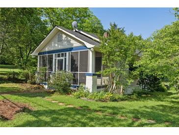 Charming home with a screened front porch, landscaped yard, and mature trees creating a welcoming curb appeal at 850 Fourth St, Stone Mountain, GA 30083