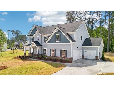 Charming two-story home with a two car garage and lush green lawn at 1452 Stephens View Dr, Loganville, GA 30052
