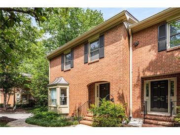 Charming brick townhome featuring a quaint arched entryway and well-manicured landscaping at 1341 Sheffield Glen Ne Way, Atlanta, GA 30329