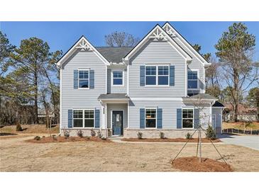 Charming two-story home with blue shutters and landscaped front yard, ready for new owners at 1462 Stephens View Dr, Loganville, GA 30052
