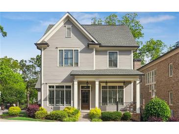 Charming two-story home featuring a covered front porch, classic gray siding, and beautifully manicured landscaping at 5981 Brundage Ln, Norcross, GA 30071