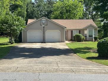Charming single-story home featuring an attached two-car garage, manicured lawn, and traditional architectural details at 3217 New Rutledge Nw Rd, Kennesaw, GA 30152