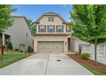 Charming two-story home with a brick facade, a two-car garage, and a well-maintained lawn at 1347 Elderwood Way, Cumming, GA 30041