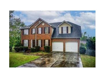 Charming two-story brick home featuring a two-car garage and a well-maintained front lawn at 2121 Silva Ct, Conley, GA 30288