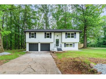 Charming two-story home with a well-maintained front yard and a two car garage at 5857 Earlwane Dr, Lithonia, GA 30058
