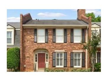Charming brick townhome featuring multi-pane windows with black shutters and a red front door at 27 Jefferson Hill Ne Pl, Atlanta, GA 30342
