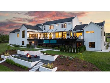 Stunning rear exterior showcasing a modern design with a built-in pool and a cozy fire pit area at 5160 Howard A Rd, Cumming, GA 30040