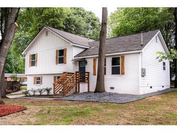 Charming two-story home with fresh exterior paint, lovely landscaping, wooden shutters, and inviting entry stairs at 8420 Sheridan Dr, Jonesboro, GA 30236
