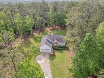 An aerial view of a charming home nestled in a lush forest setting at 2180 Briarwood Ct, Villa Rica, GA 30180