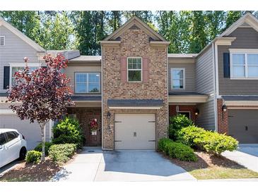 Charming townhome with brick facade, attached garage, and inviting front garden at 2534 Norwood Park Xing, Atlanta, GA 30340
