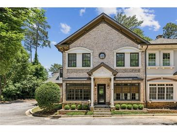 Charming brick townhome featuring manicured landscaping, stately pillars and decorative window accents at 3113 Lenox Ne Rd # 6, Atlanta, GA 30324