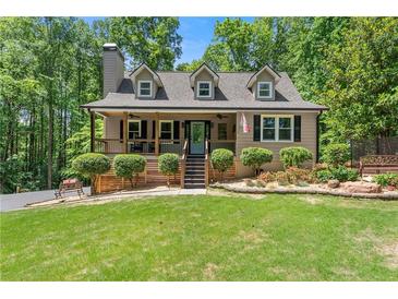 Charming home with a well-manicured lawn, inviting front porch, and mature trees at 2170 Jonquil Ct, Canton, GA 30115