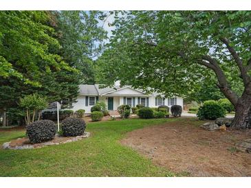 Well-maintained, single-story home with lush landscaping, a welcoming front yard, and mature trees at 2384 Shadowood Sw Dr, Conyers, GA 30094