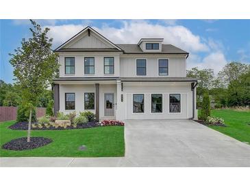 Beautiful two-story home with a manicured lawn, elegant landscaping, and a spacious driveway at 2700 Westgate Park Dr, Loganville, GA 30052