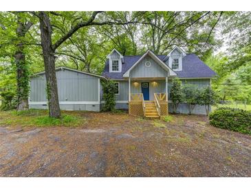 Charming home featuring light blue siding, dormer windows, and a welcoming front porch at 23 Club Dr, Locust Grove, GA 30248