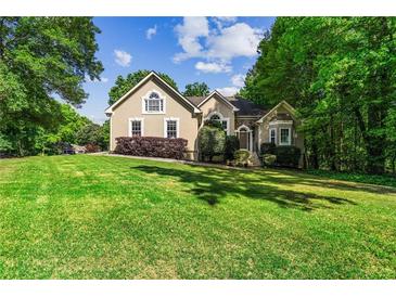 Charming home with a beautifully manicured front yard and mature trees at 1694 Peachcrest Ct, Lawrenceville, GA 30043