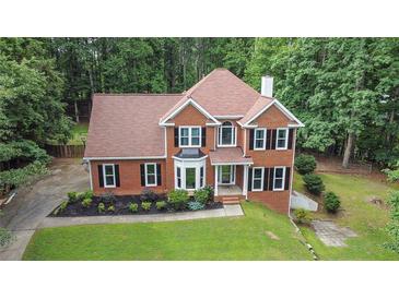 Charming two-story brick home with a well-manicured lawn and mature trees at 2482 Windchase Dr, Buford, GA 30518