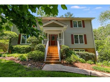 Traditional two-story home with red door, brick stairs, white railing, and lush landscaping at 9041 Par Dr, Douglasville, GA 30134