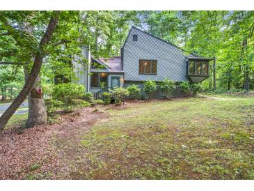 View of the house from the front yard surrounded by mature trees and landscaping at 1909 Winding Creek Sw Ln, Marietta, GA 30064
