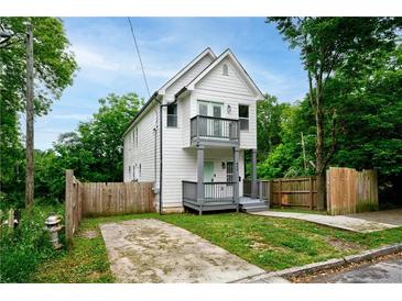 Charming two-story home with a white exterior, gray trim, small balconies, and well-kept lawn at 848 Fox Nw St, Atlanta, GA 30318