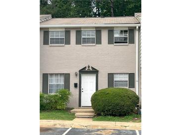 Charming townhome with three windows and front door with dark shutters and greenery at 4701 Flat Shoals Rd # 41-F, Union City, GA 30291