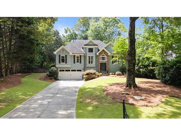 Charming two-story home featuring a well-manicured lawn and inviting curb appeal at 7635 Wynfield Dr, Cumming, GA 30040