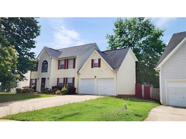Charming two-story home with a two-car garage, red shutters, and a well-manicured lawn at 130 Hazelhurst Dr, Covington, GA 30016