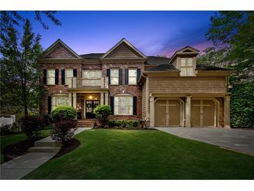 Stunning two-story brick home with a well-manicured lawn and a three-car garage, creating an inviting curb appeal at 4840 Spring Park Cir, Suwanee, GA 30024