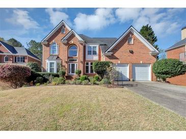 Charming two-story brick home featuring an attached two-car garage and manicured landscaping at , Suwanee, GA 30024