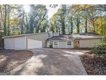 Charming one-story house with a garage, surrounded by lush trees at 5474 Post Road Pass, Stone Mountain, GA 30088
