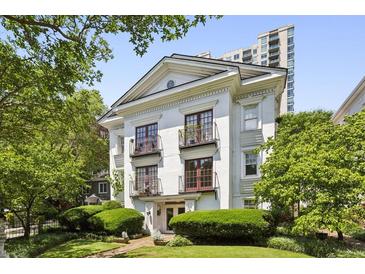 Elegant white building featuring balconies, framed by lush greenery and a well-manicured lawn at 1072 Piedmont Ne Ave # 101, Atlanta, GA 30309