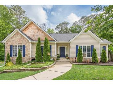 Charming home featuring a stone facade, manicured lawn, and a welcoming walkway, and eye-catching blue shutters at 188 Cooper Creek Dr, Dallas, GA 30157