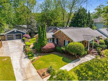 Charming brick home featuring mature landscaping, a detached garage, and a well-manicured lawn at 1041 Standard Ne Dr, Brookhaven, GA 30319