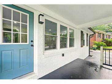 Inviting front entrance with blue door and white brick facade with large windows at 163 Oakcliff Ct, South Fulton, GA 30331