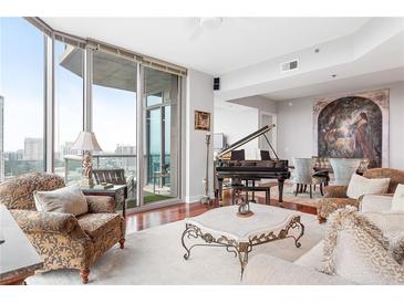 Bright living room featuring floor to ceiling windows, hardwood floors, and a grand piano at 2795 Peachtree Ne Rd # 2101, Atlanta, GA 30305
