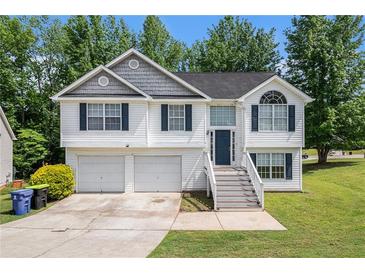 Charming two-story home featuring a two-car garage and a welcoming front entrance with a staircase at 115 Manx Dr, Grantville, GA 30220