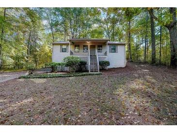 Cozy home featuring a small front porch with natural surroundings at 12 Woodland St, Dallas, GA 30157