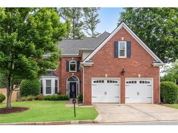 Traditional brick home featuring a two-car garage and manicured front lawn at 2500 Madison Commons, Atlanta, GA 30360