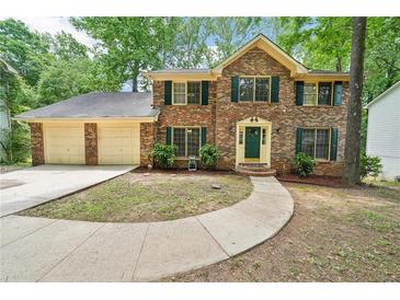 Charming brick two-story home with a two-car garage and a well-manicured lawn at 5141 Rocky Run, Stone Mountain, GA 30088