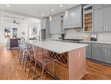 Bright, open kitchen with a large island, gray cabinets, stainless appliances, and hardwood floors at 2018 Presley Ne Way, Atlanta, GA 30317