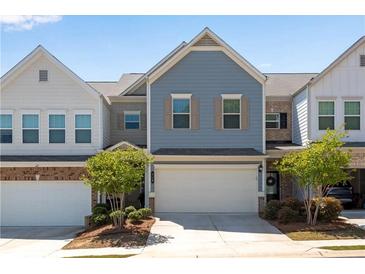 Charming two-story townhome with blue siding, a two-car garage, and neatly landscaped front yard at 218 Jordan Dr, Woodstock, GA 30188