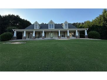 Charming single-Gathering home with an expansive lawn, a welcoming front porch, and well-maintained landscaping at 130 Honey Ln, Fayetteville, GA 30214