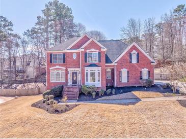 Charming two-story red brick home featuring a well-manicured lawn and inviting front entrance at 4213 Bretdale Nw Run, Kennesaw, GA 30152