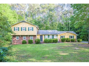 Charming two-story home with a brick facade and a well-manicured lawn surrounded by lush greenery at 2037 Cliffton Ter, Snellville, GA 30039