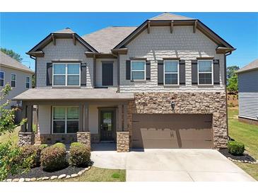 Charming two-story home featuring stone accents, a covered porch, and a two-car garage at 4255 Sunflower Cir, Cumming, GA 30040