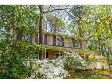 Charming two-story home with mature trees, lush landscaping and front porch at 6795 Brandon Mill Rd, Atlanta, GA 30328